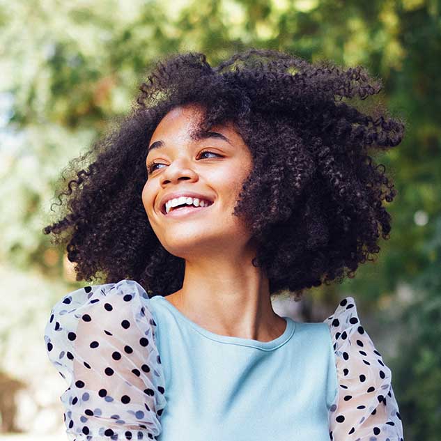 Happy african american teen girl in casual cloth. Smiling darksk Dentist in Kernersville, NC