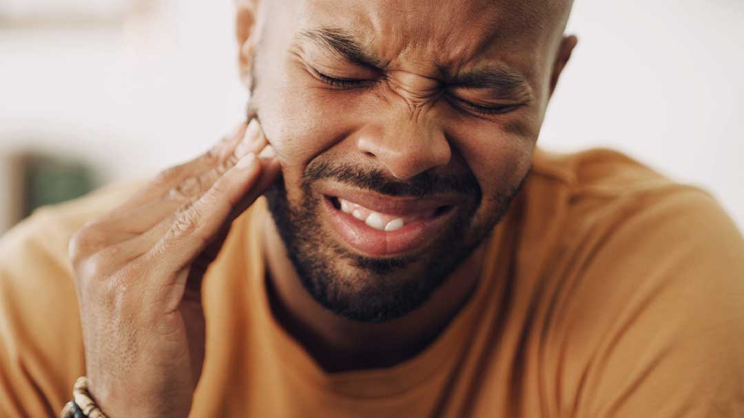 Man holding mouth in dental pain